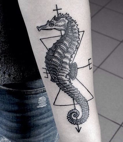 Hyper realistic black seahorse tattoo on the arm