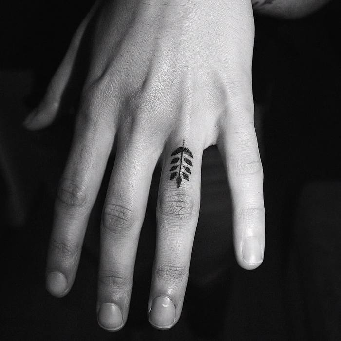 Little black fern tattoo on the ring finger