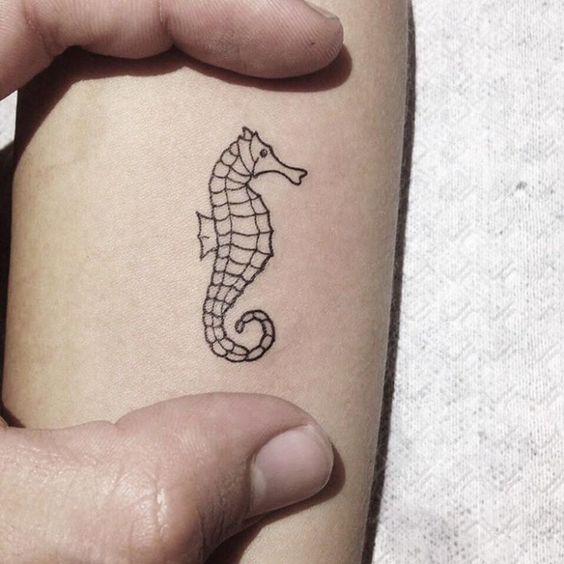 Little black geometric tattoo of a seahorse