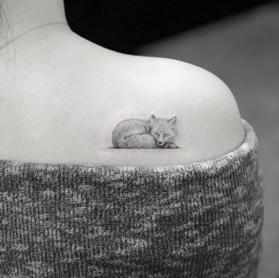 Little sleeping fox tattoo on the right shoulder blade