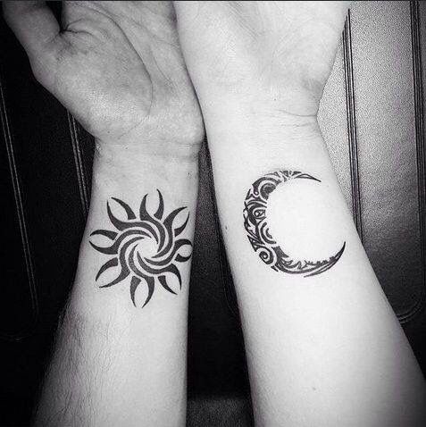 Matching tribal sun and moon tattoos on inner wrists