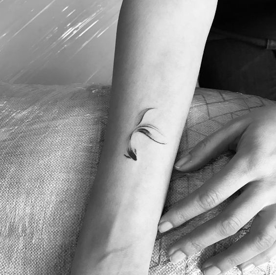 Minimalist black koi fish tattoo on the arm