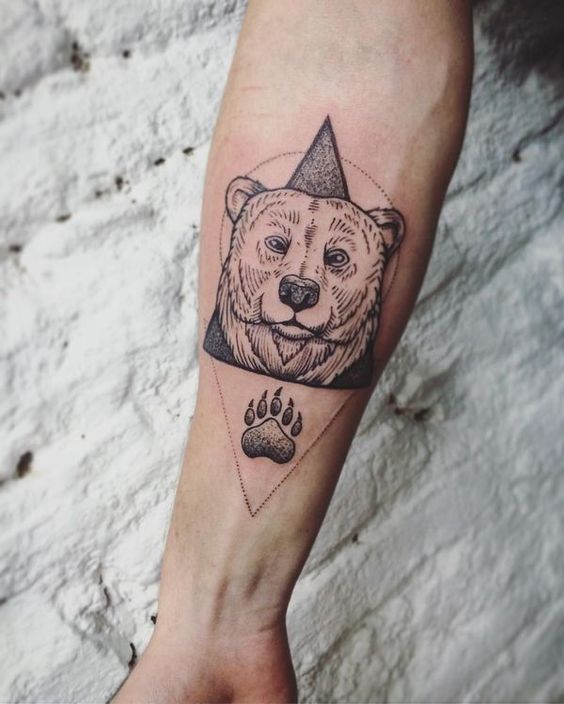 Monochrome bear and paw tattoo on the arm