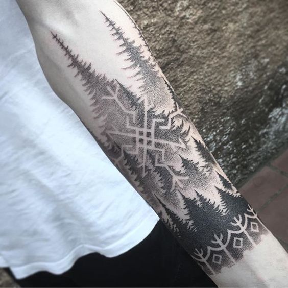 Nordic symbol and forest negative space tattoo on the arm