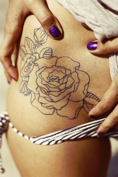 Outline blue rose tattoo on the right hip and belly