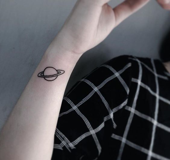 Outline tattoo of planet saturn on the right wrist