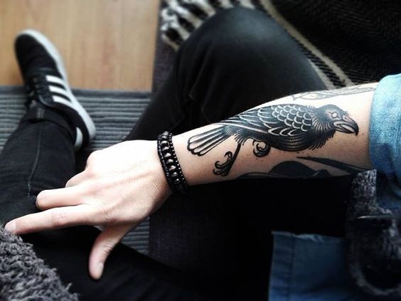 Raven blackwork tattoo on the right forearm