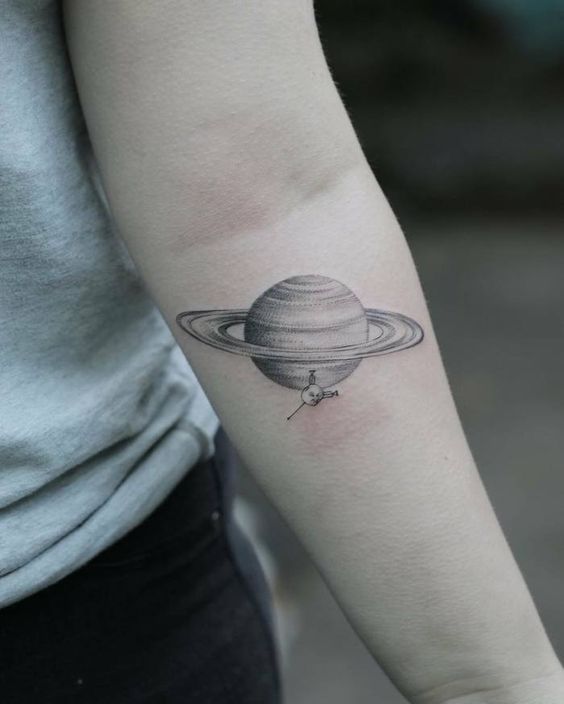 Saturn and cassini spacecraft tattoo on the arm