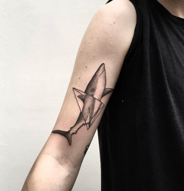Shark and triangle tattoo on the right upper arm