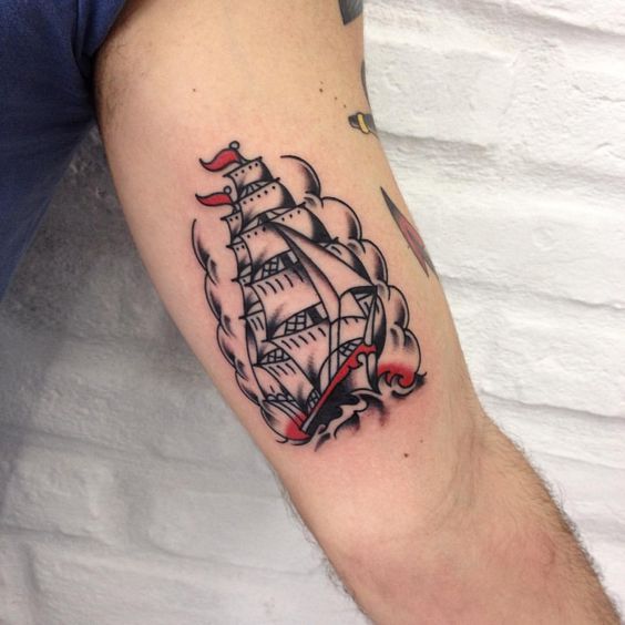 Simple black and red ship tattoo on the bicep