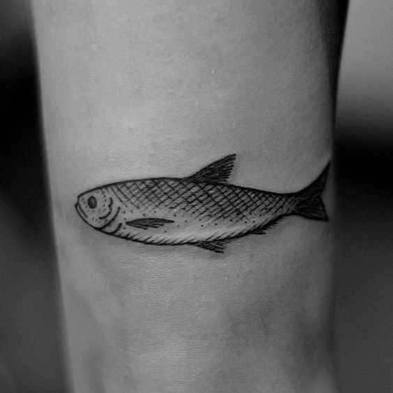 Simple black fish tattoo on the leg