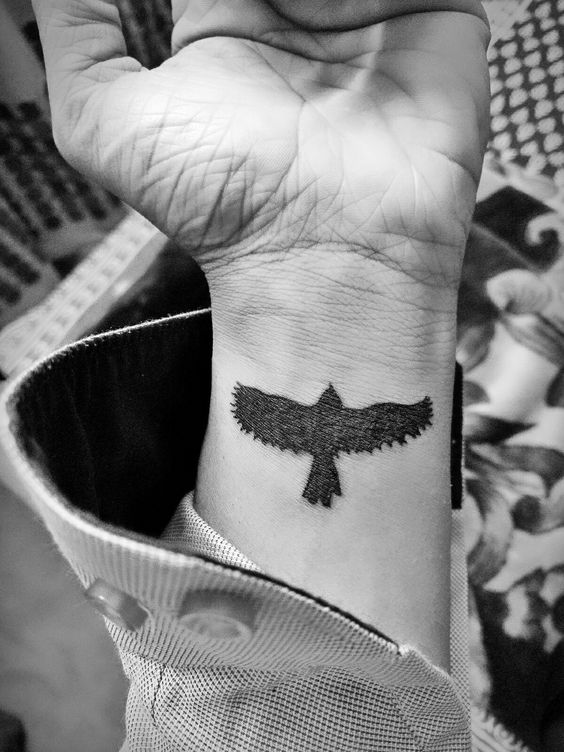 Small black raven wrist tattoo