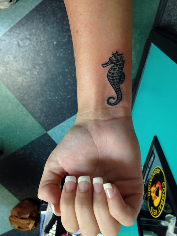Small black seahorse tattoo on the right inner wrist