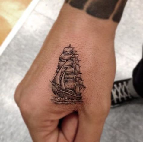 Small black ship tattoo on the right hand