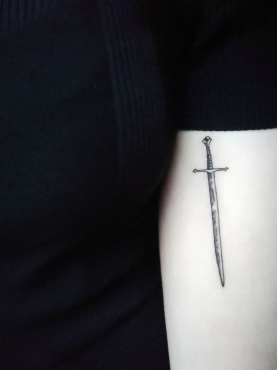 Small black sword tattoo on the arm