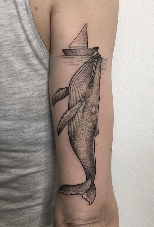 Small boat and a whale tattoo on the right arm