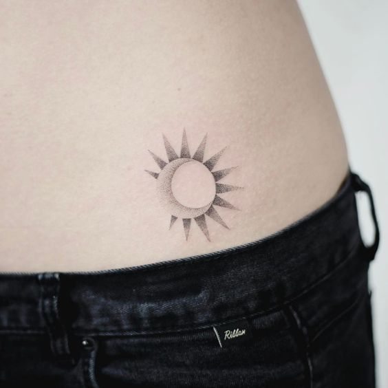 Small dotwork style moon and sun tattoo on the left hip by tattooist doy