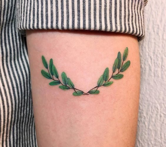 Small laurel wreath tattoo on the left arm