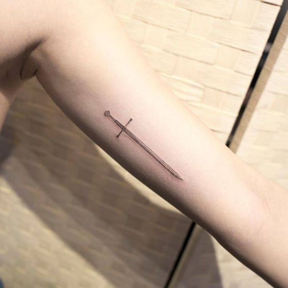 Small sword tattoo on the left upper arm