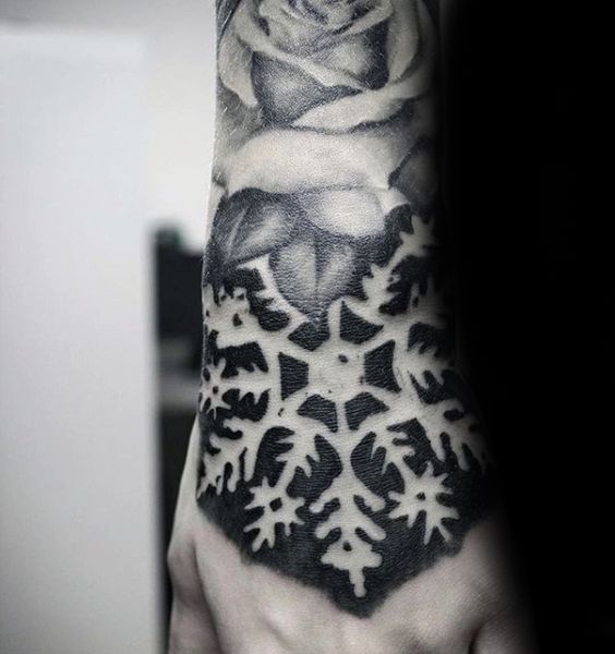 Snowflake negative space tattoo on the hand
