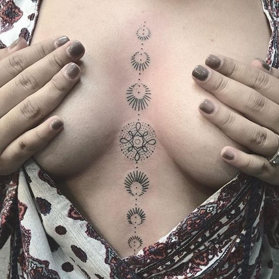 Stylized moon phase tattoo on the breastbone
