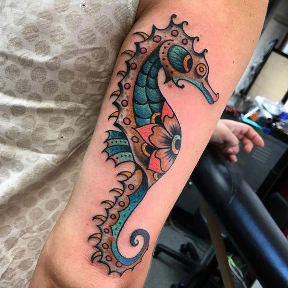Stylized traditional seahorse tattoo on the back of the right arm