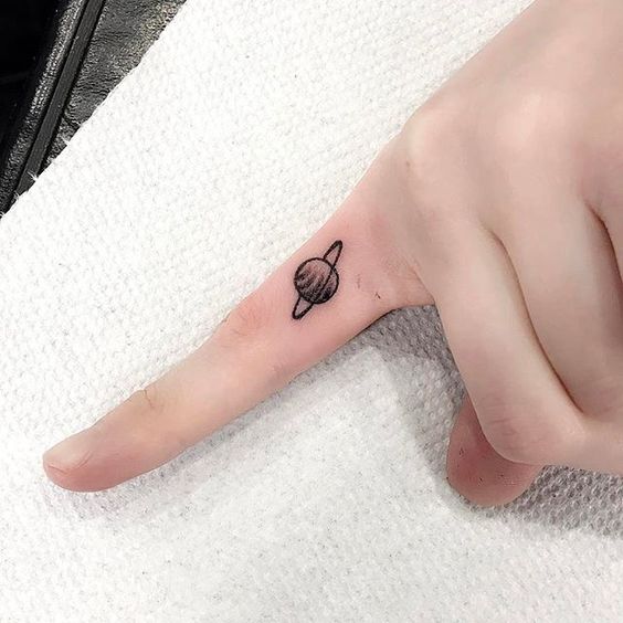 Tattoo of saturn on the index finger