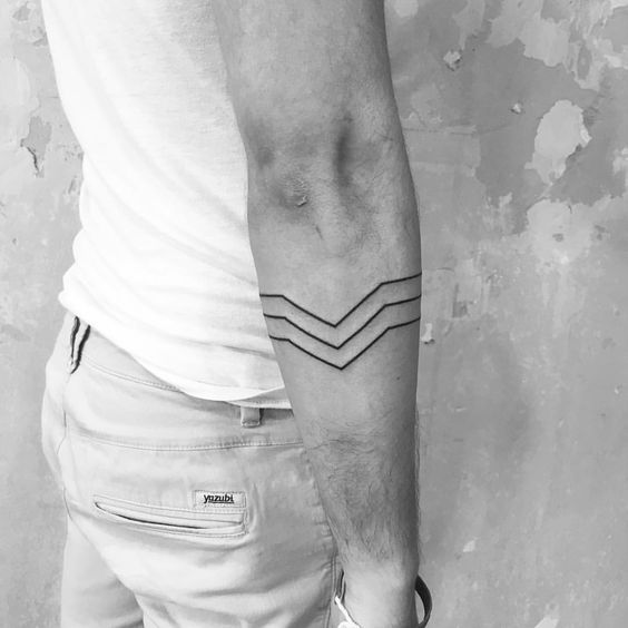 Thin black chevron lines tattoo on the arm