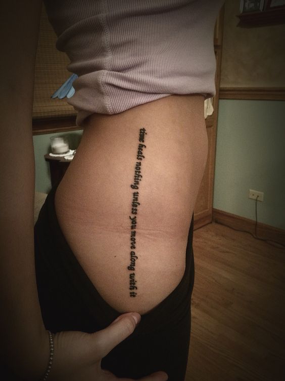 Time heals nothing unless you move along with it quote tattoo on the hip