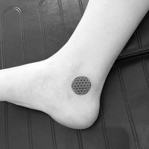 Tiny flower of life tattoo on the right inner ankle