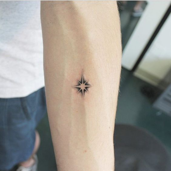Tiny negative space star tattoo