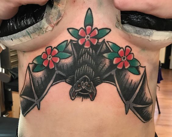 Traditional bat and flowers breastbone tattoo