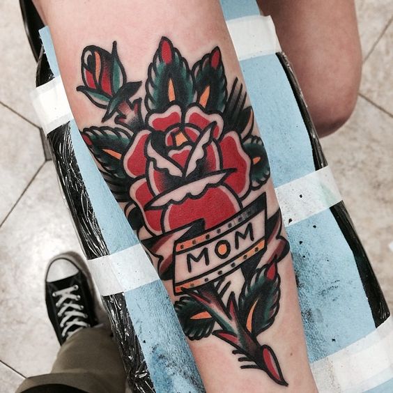 Traditional rose tattoo with a word mom on a ribbon