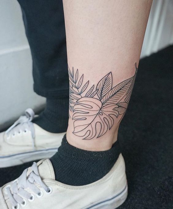 Tropical leaves tattoo around the left ankle