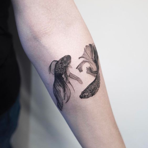 Two black Koi Fish tattoo on the left inner arm