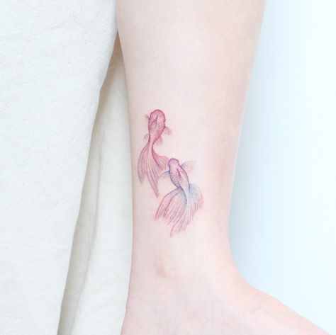 Two delicate Koi Fish tattoo on the left wrist