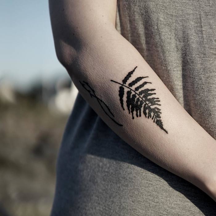 Woderful solid black tattoo of a fern