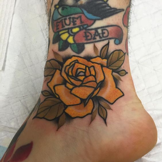 Yellow rose tattoo over the ankle bone