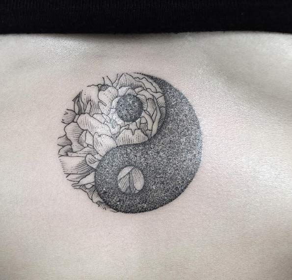 Yin and yang and peony circular tattoo on the sternum