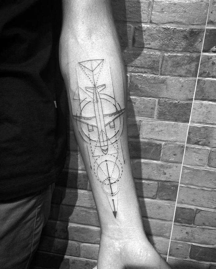 Airplane tattoo with geometric elements on the forearm