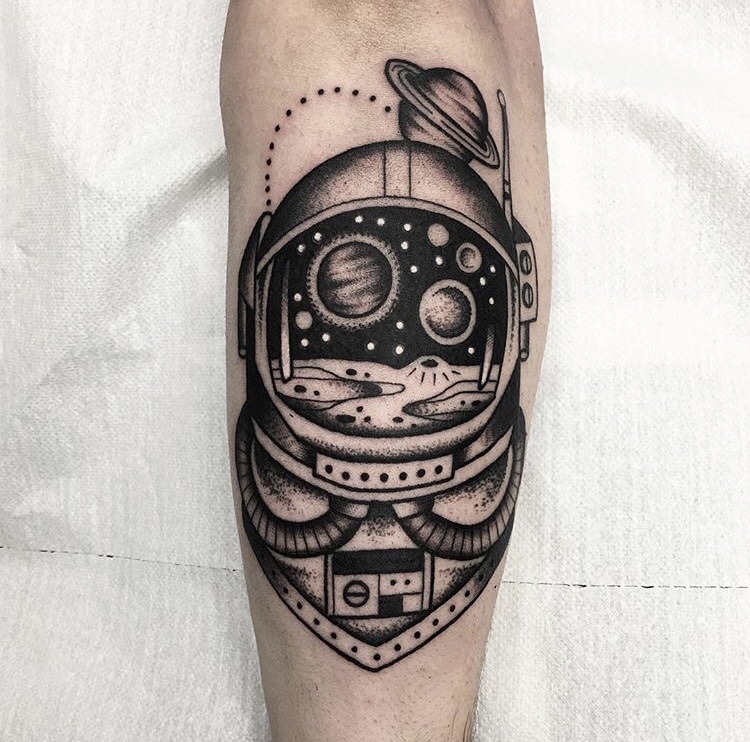 Astronaut helmet tattoo with a reflection of the cosmos