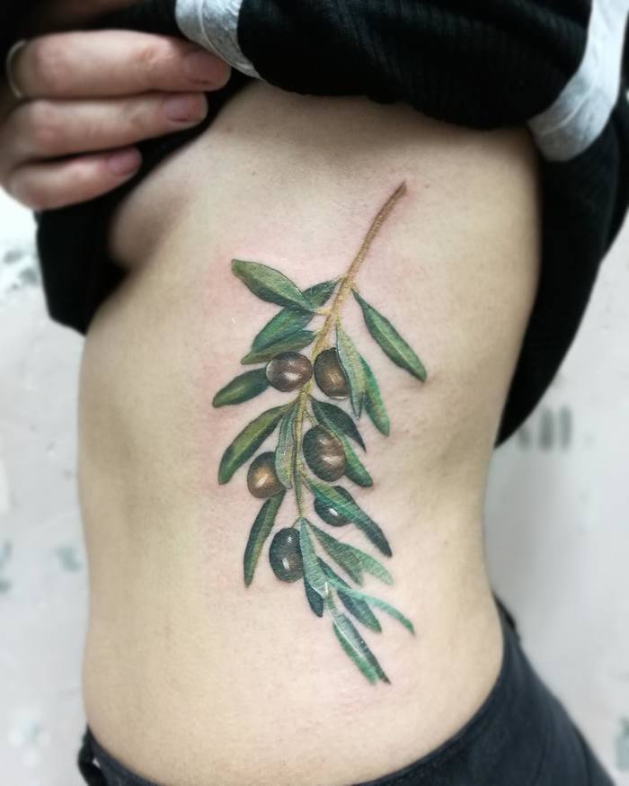 Beautiful hyper realistic olive twig tattoo on the left rib cage