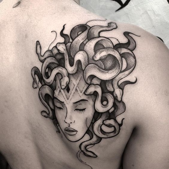 Black and grey medusa head tattoo on the right shoulder blade