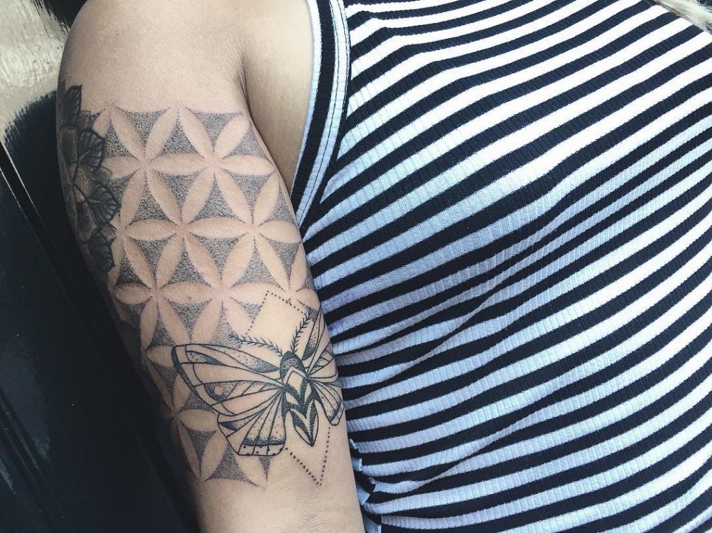 Black moth and sacred geometry tattoo on the right arm