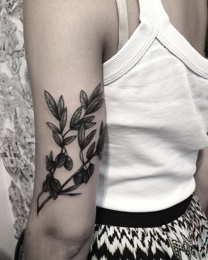 Blackwork olive branch tattoo on the tricep
