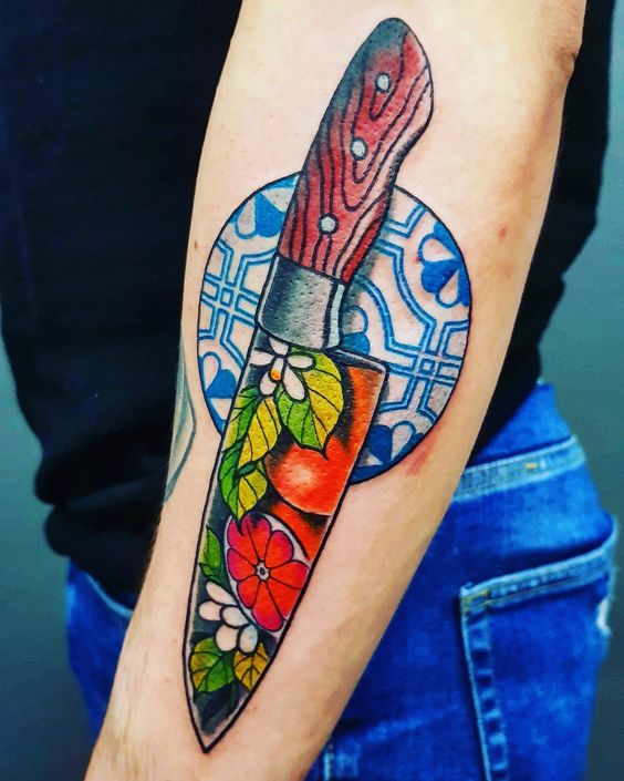 Chef knife tattoo with sicilian stile ceramic in the background