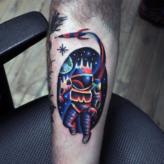Colorful astronaut and spaceship tattoo on the arm
