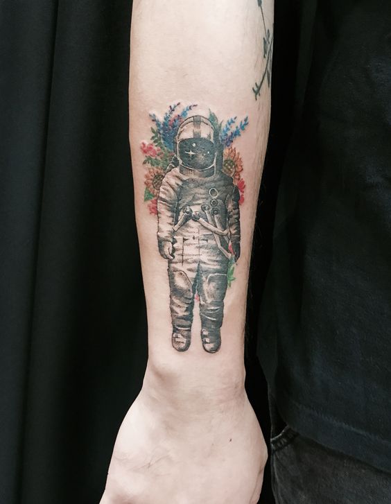 Cosmonaut with flowers tattoo on the right forearm