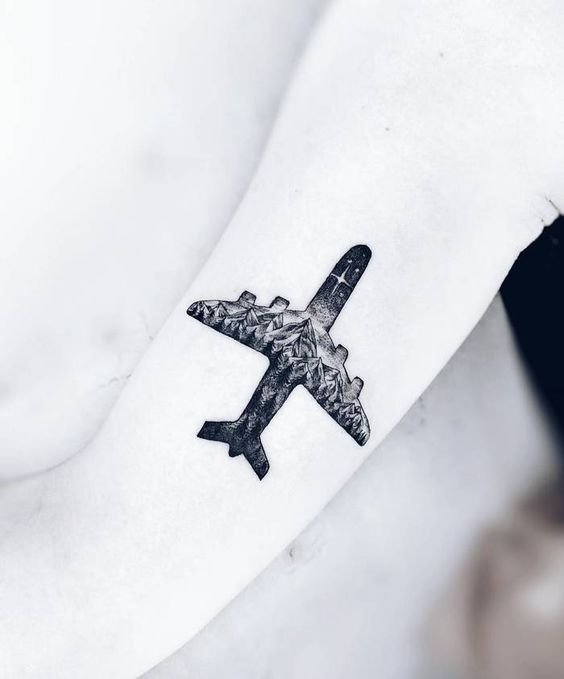 Double exposure plane and mountains tattoo