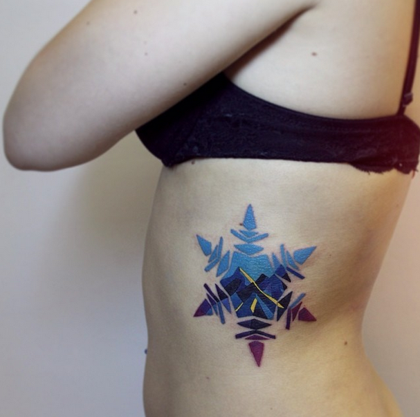 Double exposure snowflake and mountain tattoo on the left rib